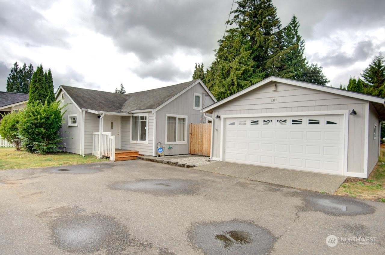 1321 Golf Club Road Southeast Lacey, WA 98503 - Photo 1 of 25 a front view of a house with a yard and garage