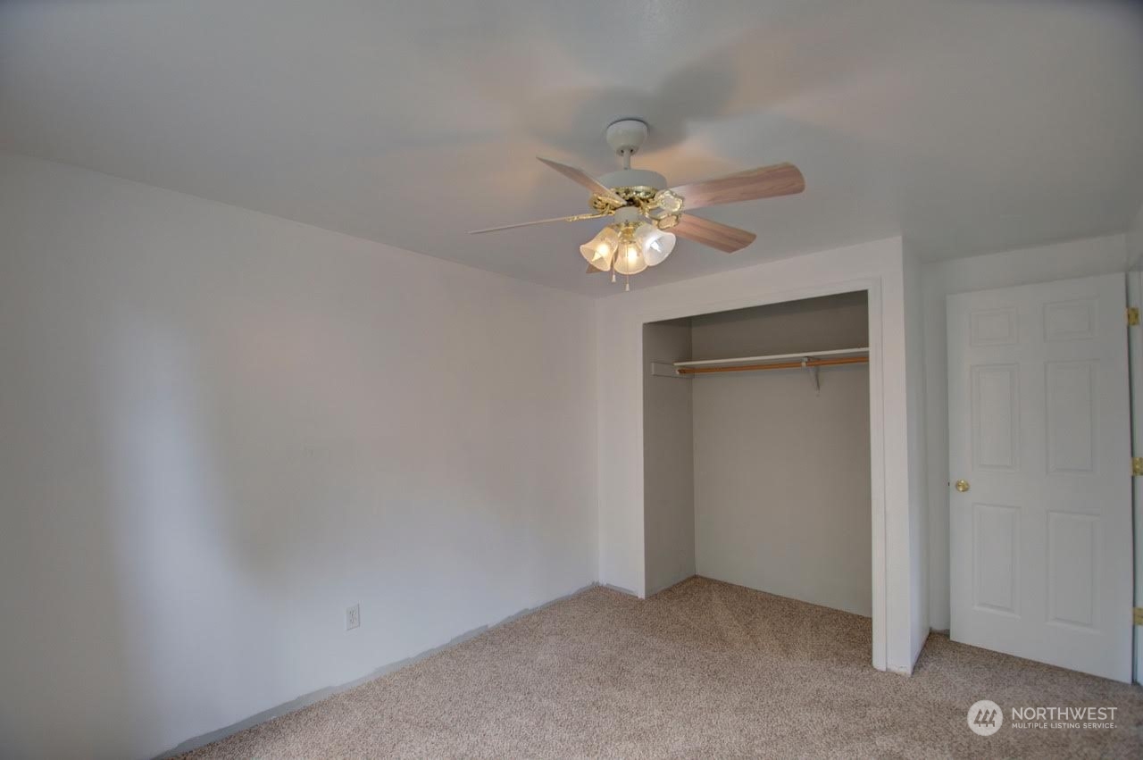 1321 Golf Club Road Southeast Lacey, WA 98503 - Photo 17 of 25 an empty room with a chandelier fan and a bathroom