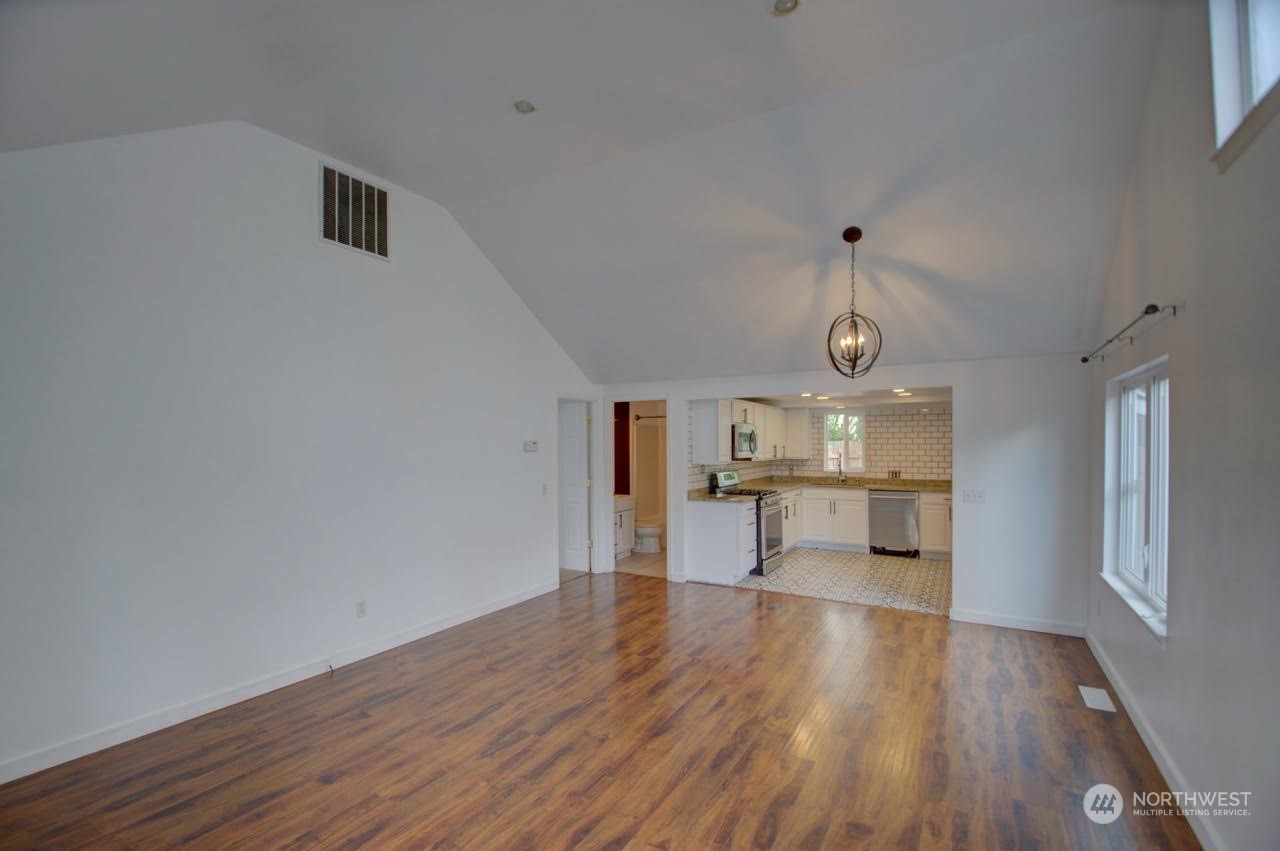 1321 Golf Club Road Southeast Lacey, WA 98503 - Photo 4 of 25 a view of a room with wooden floor and a kitchen