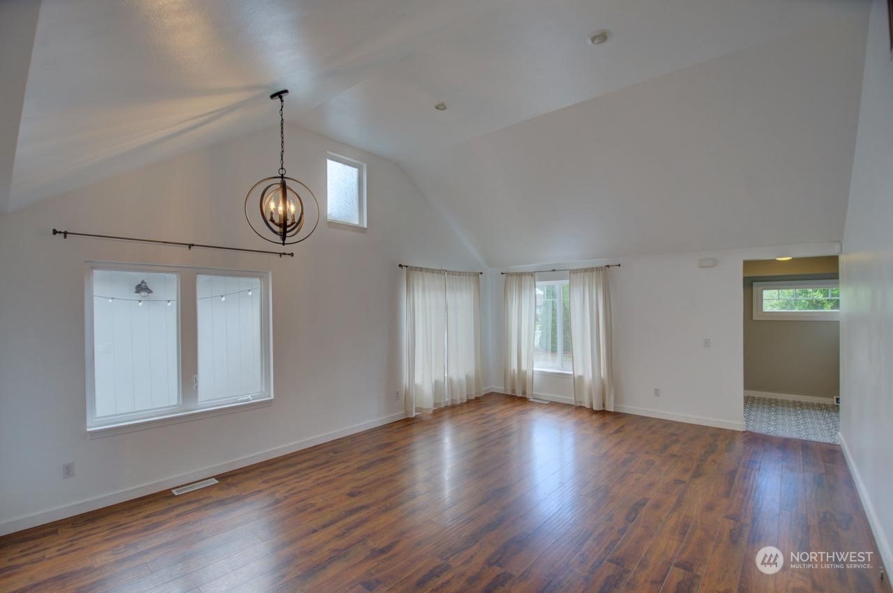 1321 Golf Club Road Southeast Lacey, WA 98503 - Photo 6 of 25 a view of an empty room with wooden floor and a window