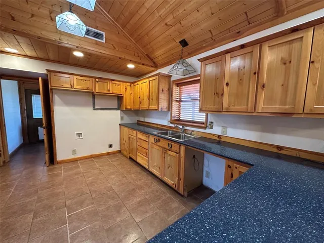 a kitchen with a sink window and cabinets