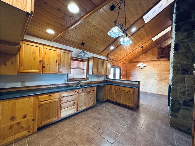 a kitchen with granite countertop a sink a counter top space and cabinets