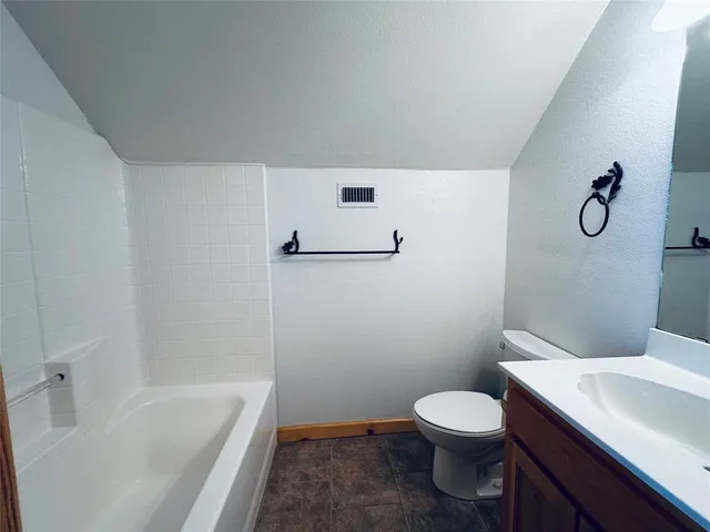 a white toilet sitting next to a bath tub