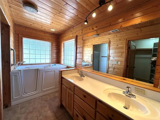 a bathroom with double vanity and a bathtub