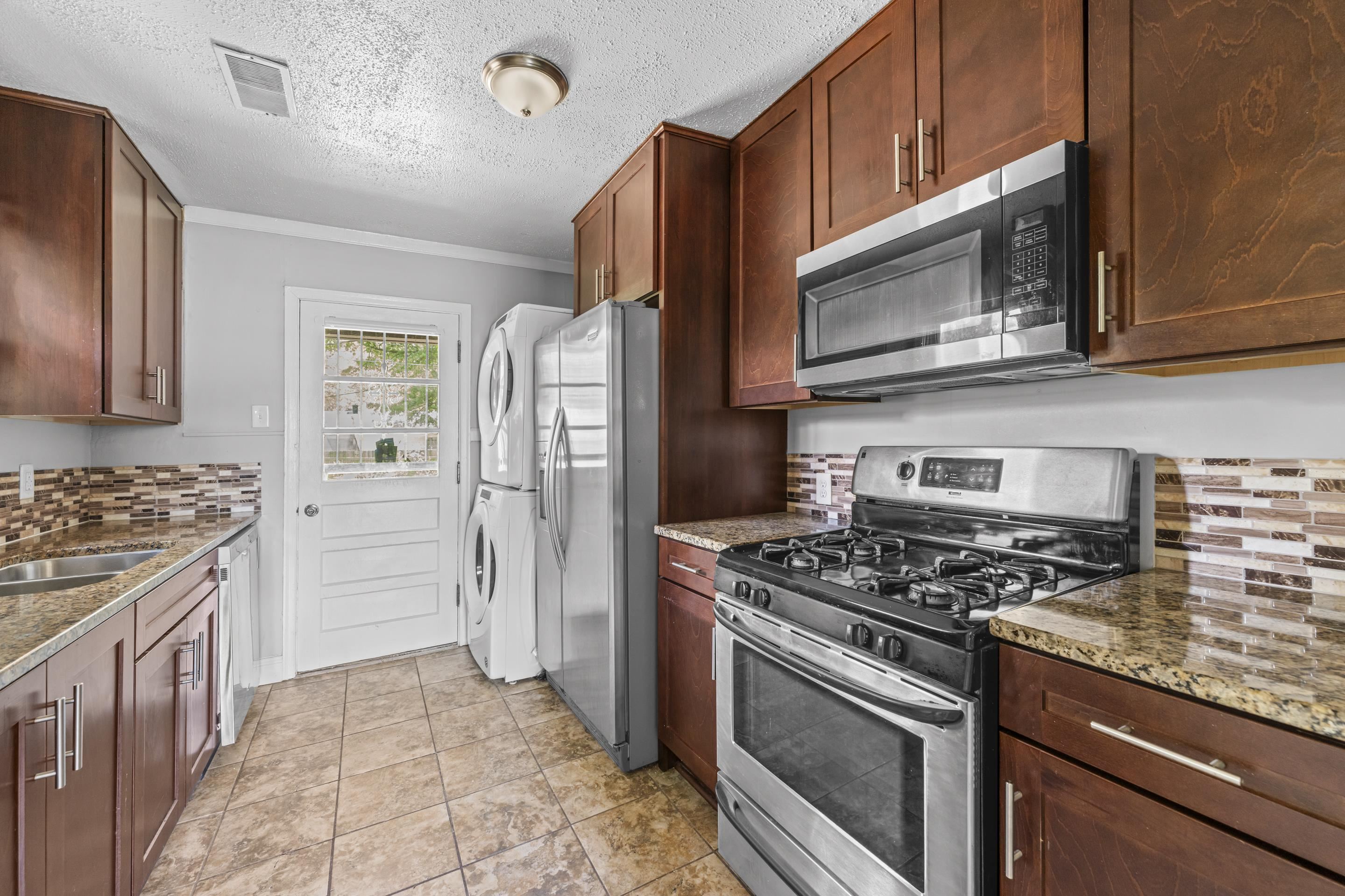 1418 South Perkins Road Memphis, TN 38117 - Photo 3 of 21 a kitchen with stainless steel appliances granite countertop a stove microwave refrigerator and sink