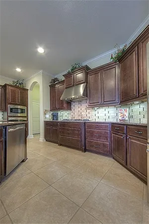 a kitchen with granite countertop a stove and cabinets