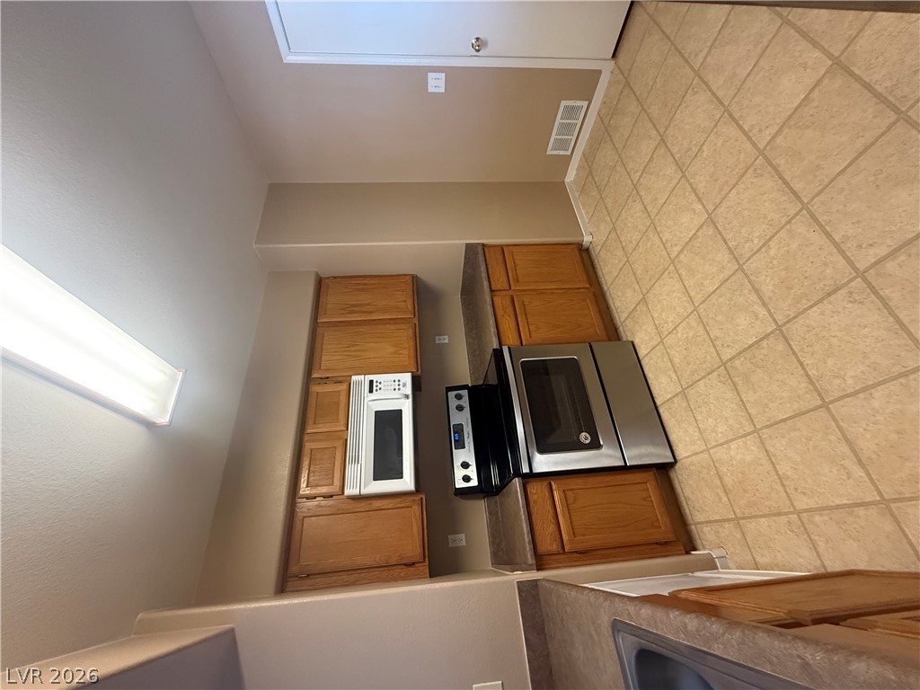 7255 West Sunset Road, Unit 2052 Las Vegas, NV 89113 - Photo 10 of 16 Well-equipped kitchen featuring essential appliances and light wood cabinetry.