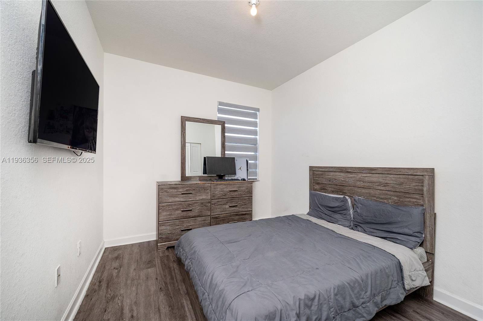 23061 Southwest 128th Place Miami, FL 33177 - Photo 13 of 28 a bedroom with a bed and a flat screen tv