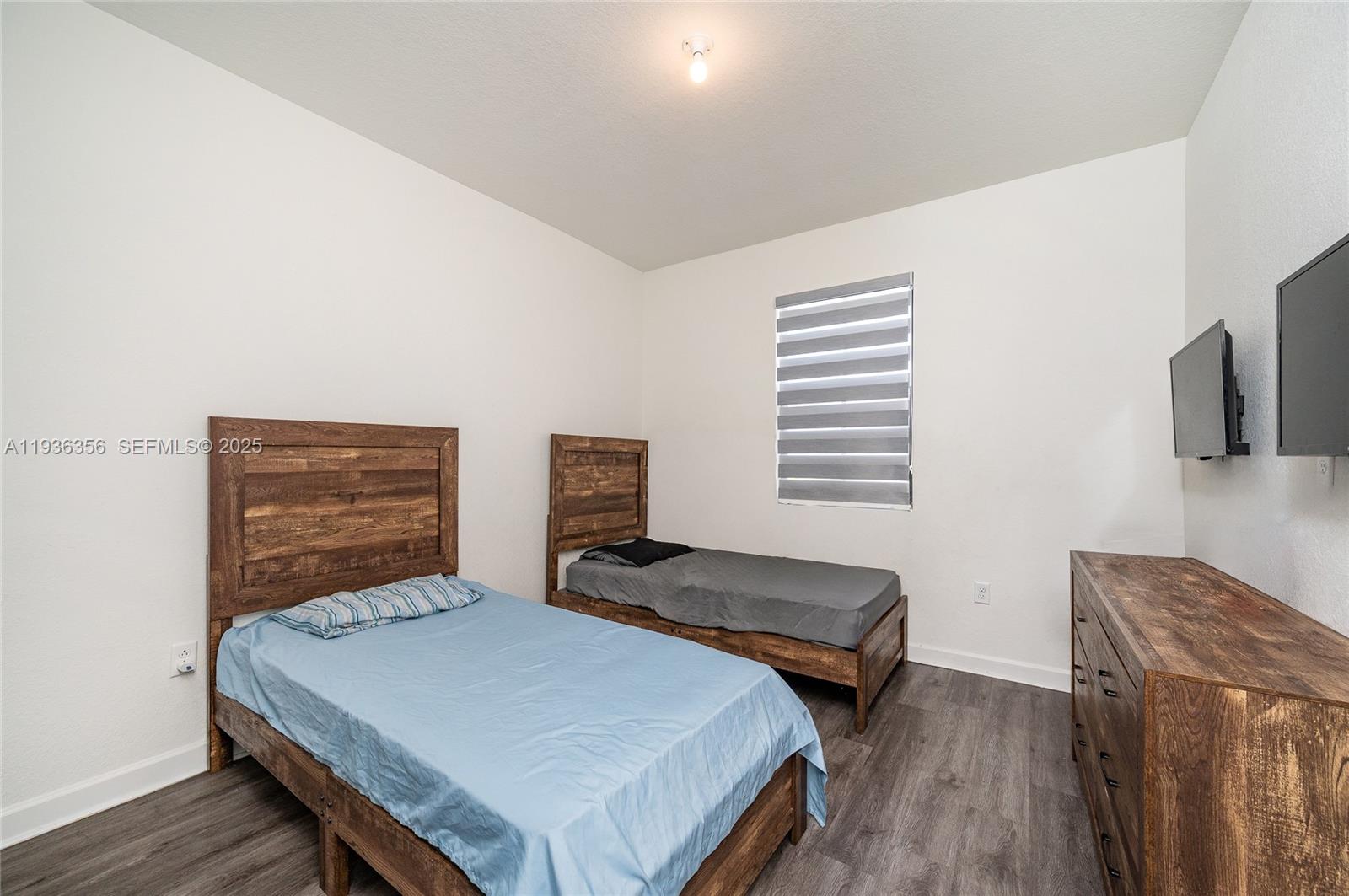 23061 Southwest 128th Place Miami, FL 33177 - Photo 21 of 28 a bedroom with two beds and painting on the wall