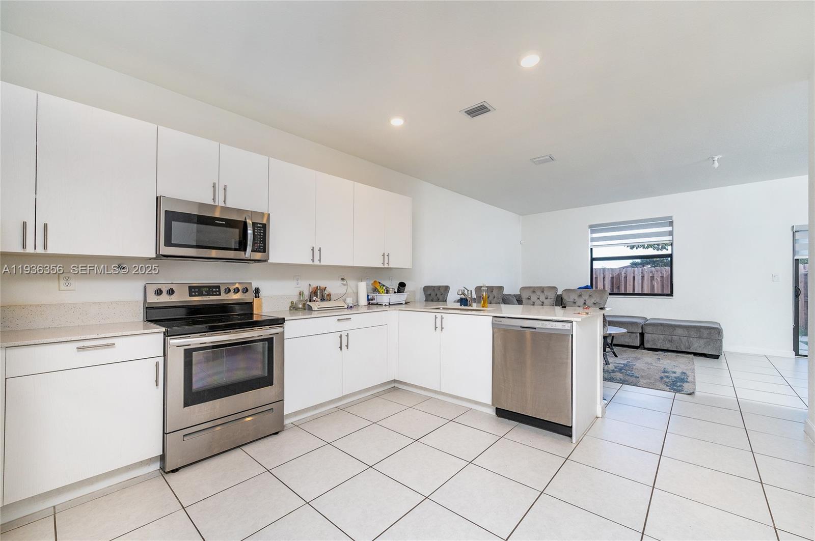 23061 Southwest 128th Place Miami, FL 33177 - Photo 4 of 28 a kitchen with a stove top oven and cabinets