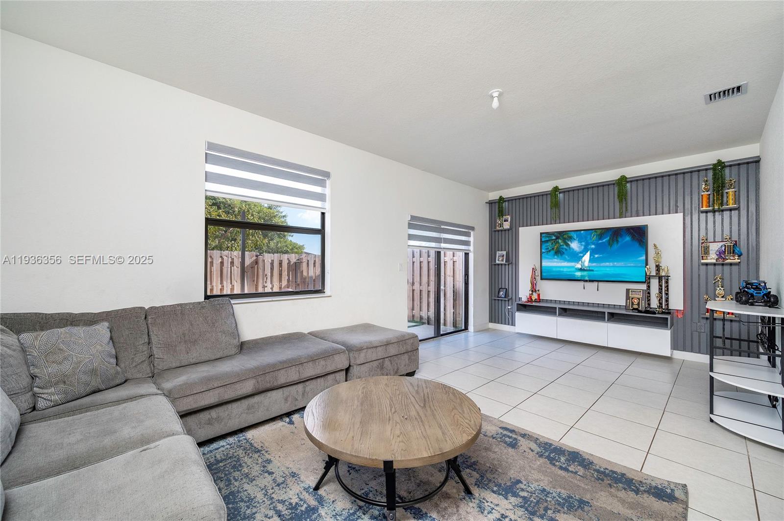 23061 Southwest 128th Place Miami, FL 33177 - Photo 10 of 28 a living room with furniture and a flat screen tv