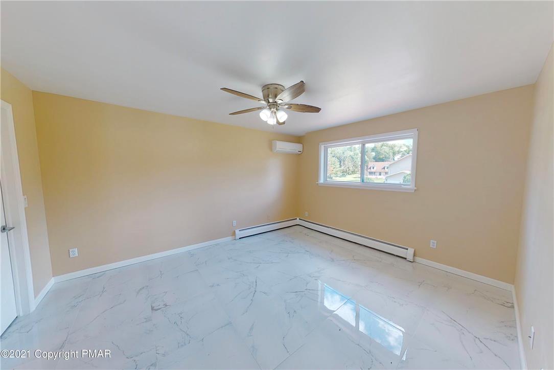 1110 Misty Ridge East Stroudsburg, PA 18302 - Photo 35 of 43 A quiet bedroom showcases a ceiling fan and a well-lit window overlooking a peaceful neighborhood.