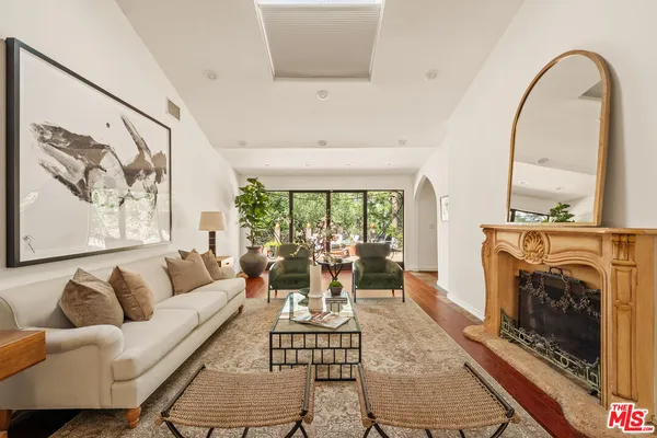 a living room with furniture a fireplace and a floor to ceiling window