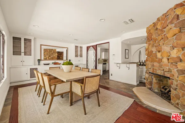 a living room with furniture a rug potted plant and a large window