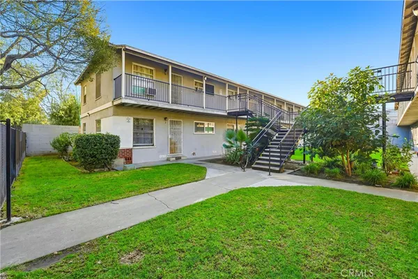 a front view of a house with a garden and plants