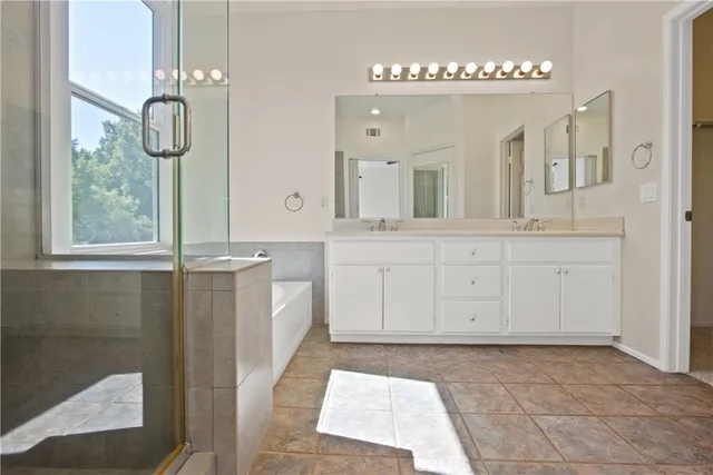 a spacious bathroom with a sink a mirror and a shower