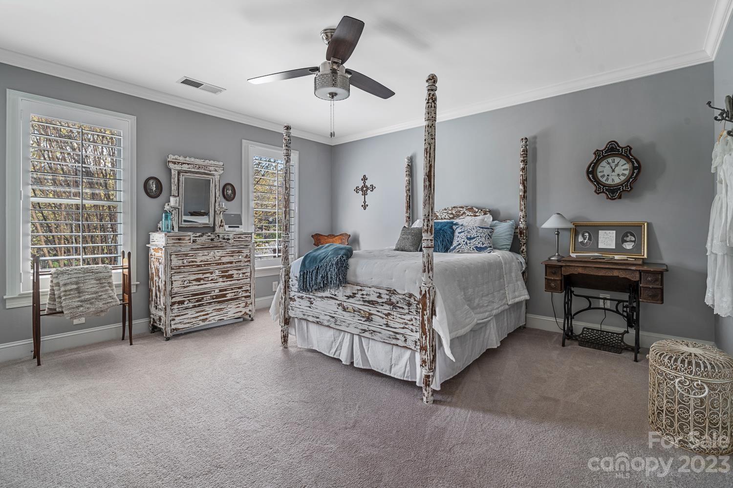 4612 Binfords Ridge Road Charlotte, NC 28226 - Photo 43 of 48 a spacious bedroom with a bed a couch and a chandelier