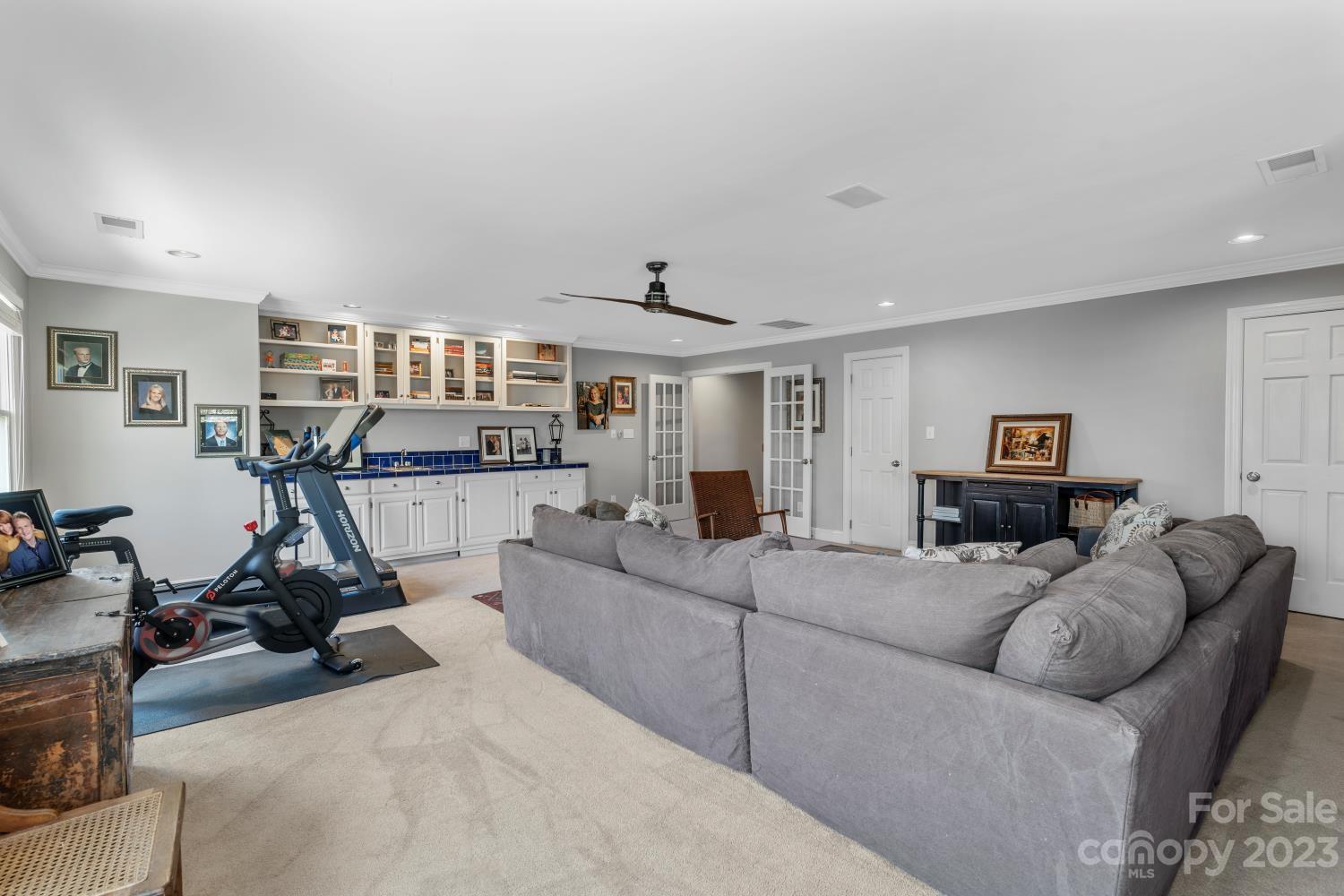 4612 Binfords Ridge Road Charlotte, NC 28226 - Photo 45 of 48 a living room with furniture a gym equipment and a flat screen tv