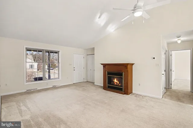 an empty room with windows and fireplace
