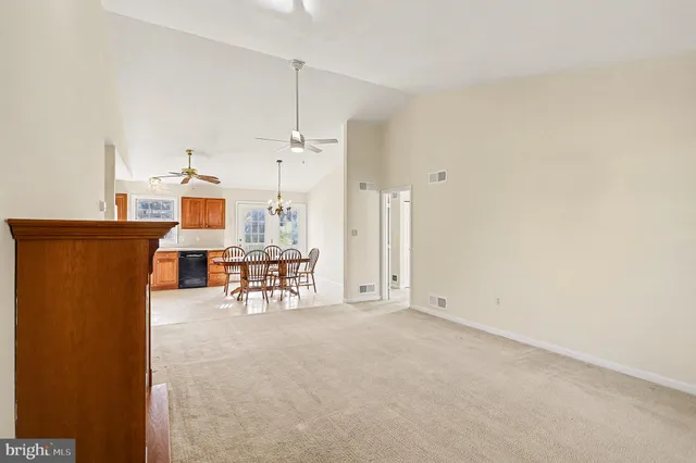 an empty room with furniture and a view of kitchen