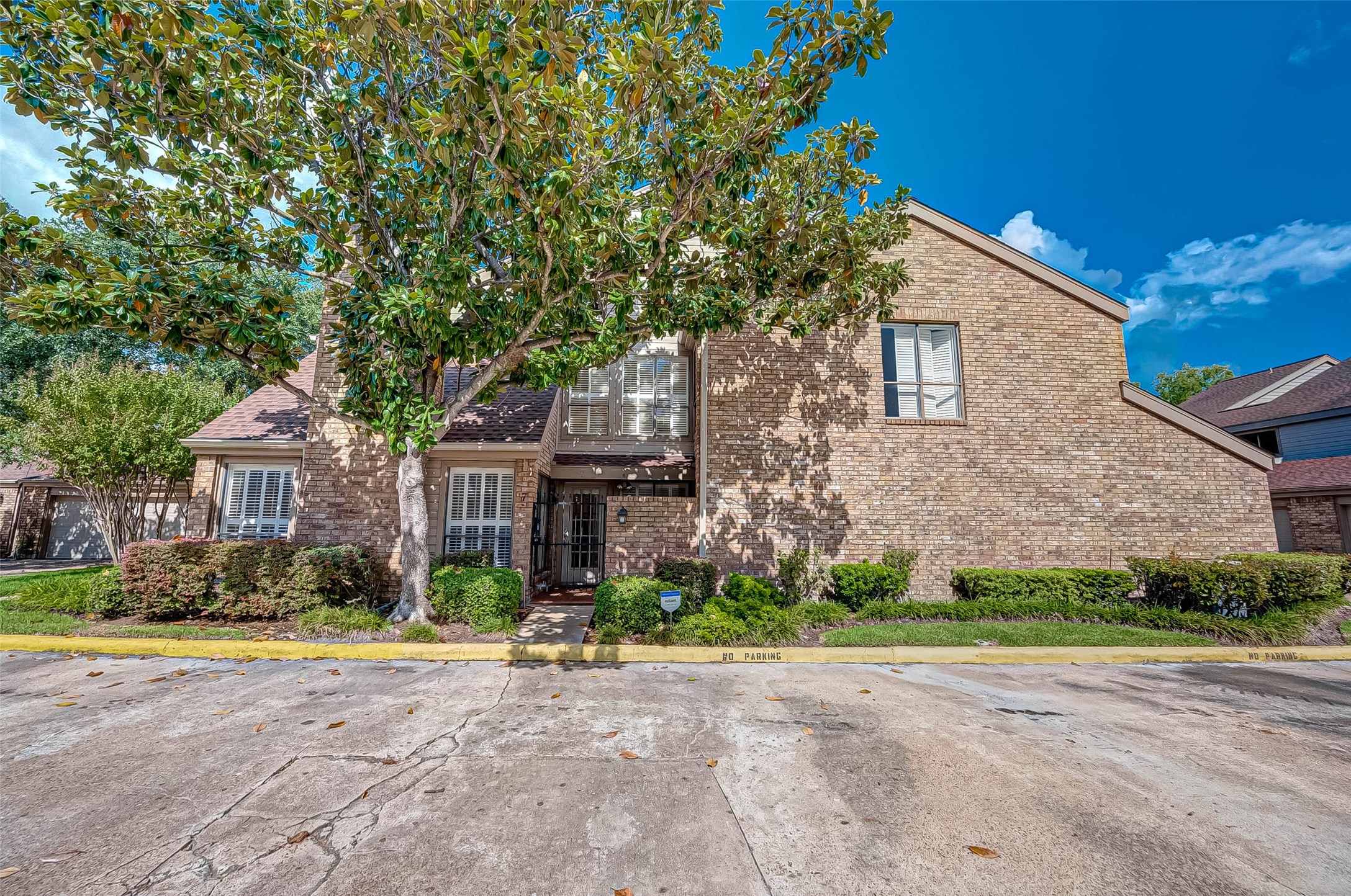 1908 Augusta Drive, Unit 7 Houston, TX 77057 - Photo 2 of 33 a front view of a house with a yard and a garage