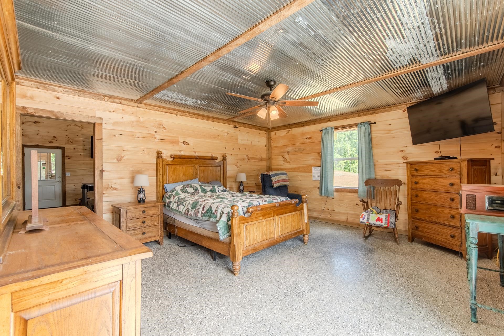 597 Hardin Graveyard Road Adamsville, TN 38310 - Photo 14 of 40 a bedroom with a bed and a flat tv screen