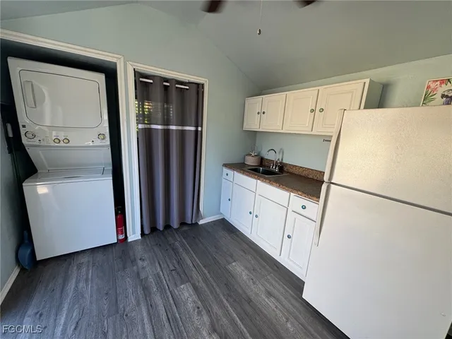 a kitchen with a refrigerator a stove top oven a sink and dishwasher with wooden floor