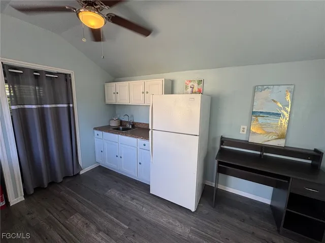 a kitchen with sink a refrigerator and wooden floor