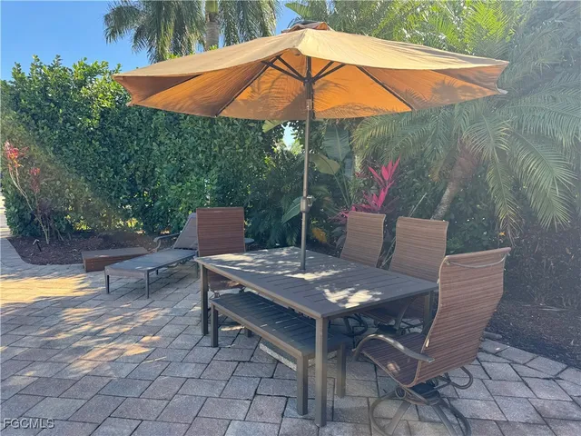 a patio with a table and chairs under an umbrella