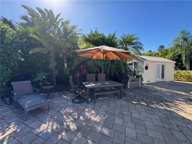 a view of a patio with a table and chairs under an umbrella