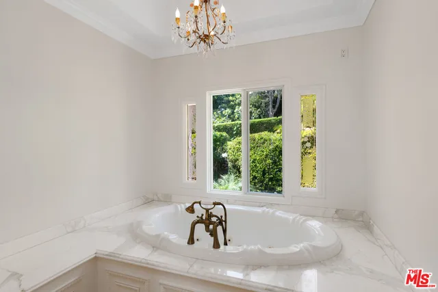 a bathroom with a sink and mirror with bathtub