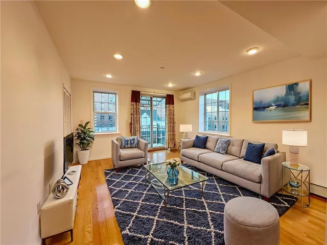 a living room with furniture a large window and a flat screen tv