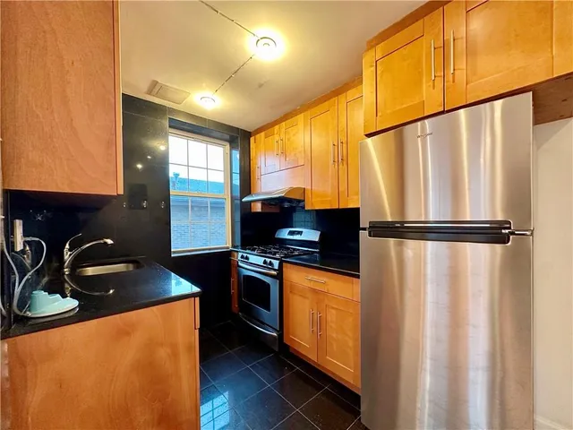 a kitchen with stainless steel appliances a sink stove and cabinets