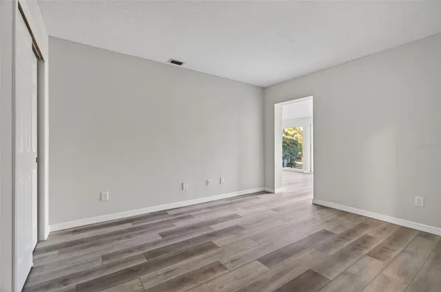 a view of an empty room with wooden floor