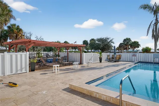 a view of a patio with a table and chairs under an umbrella with wooden fence