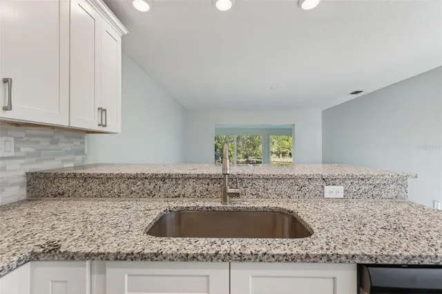 a kitchen with granite countertop a sink and a stove