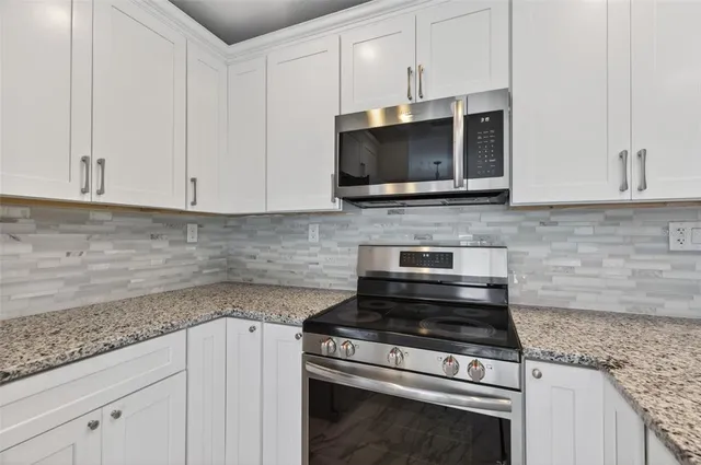 a kitchen with microwave stove and cabinets