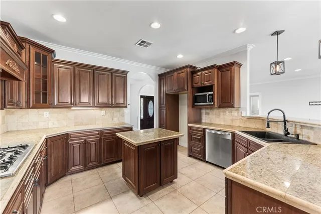 a kitchen with stainless steel appliances granite countertop a sink counter space cabinets and a stove