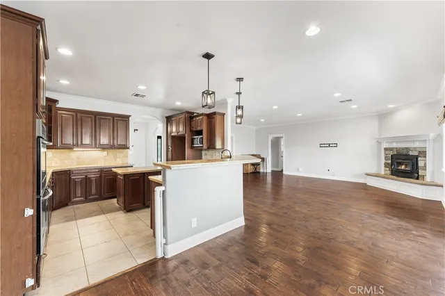 a room with stainless steel appliances kitchen island granite countertop a stove a sink and a refrigerator
