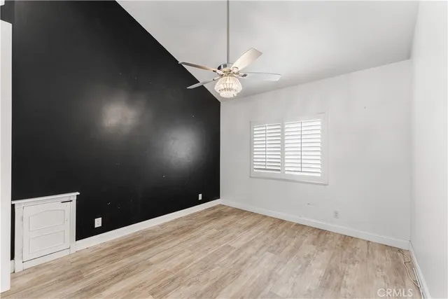 an empty room with windows and fireplace