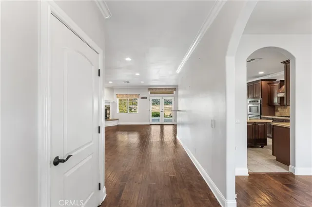 a view of a hallway view with wooden floor and living room