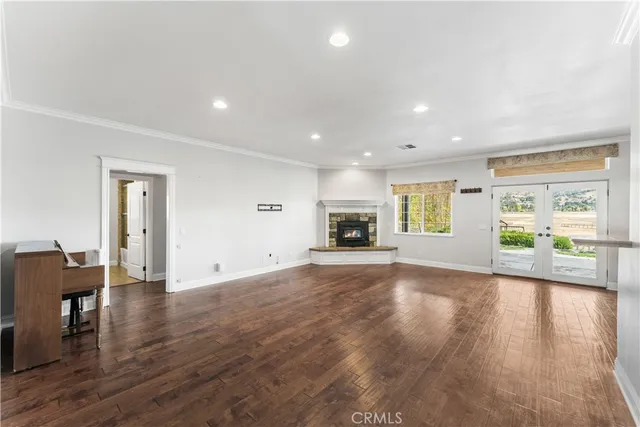 a view of empty room with wooden floor and fireplace