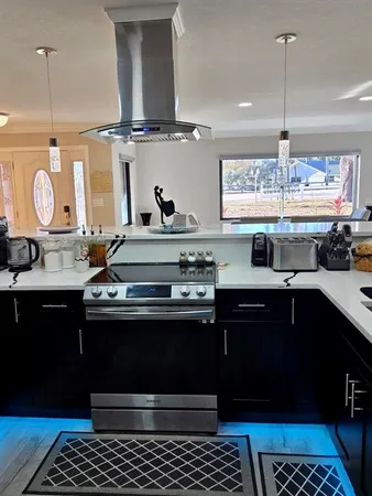 a kitchen with stainless steel appliances granite countertop a sink a stove and a wooden cabinets