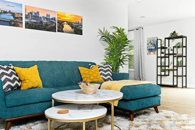 a living room with furniture flowerpot and wooden floor