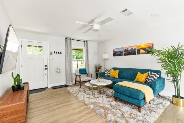 a living room with furniture and wooden floor