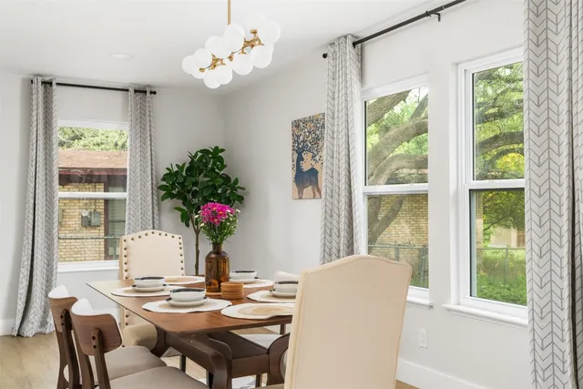 a view of a dining room with furniture large windows and wooden floor
