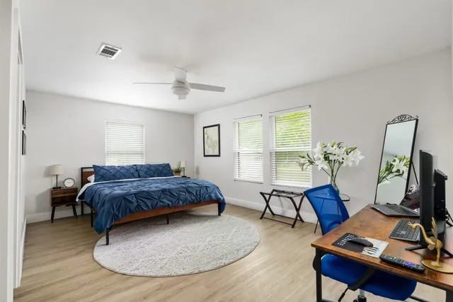 a bedroom with a bed and wooden floor