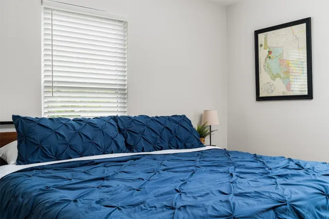 a bed sitting in a bedroom next to a window