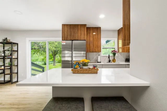 a bathroom with a sink and a large mirror next to a window
