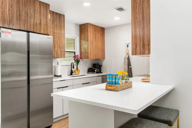 a kitchen with stainless steel appliances a sink and a refrigerator